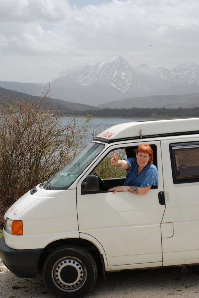 Anna su Tony Furgony in partenza, sullo sfondo il lago di Campotosto e il Gran Sasso