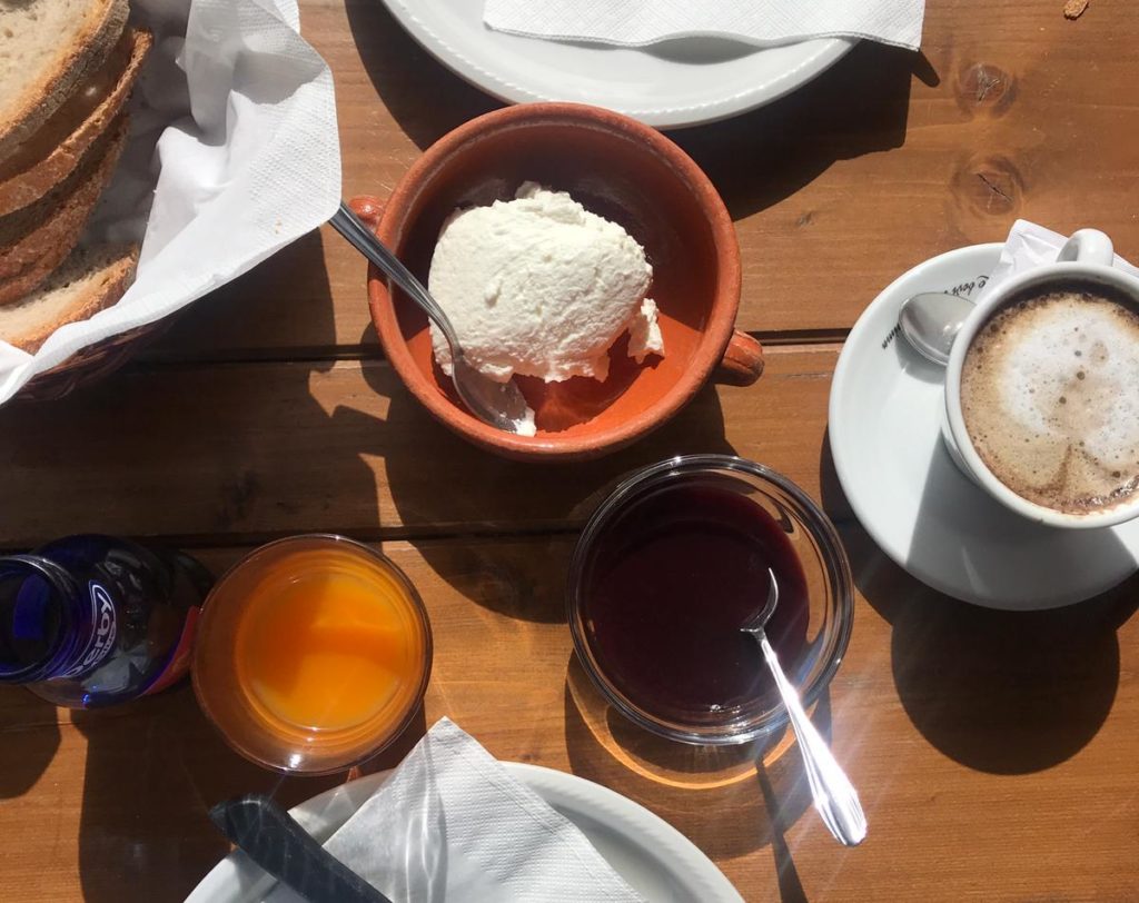 Colazione con ricotta di pecora, marmellata, pane e cappuccino